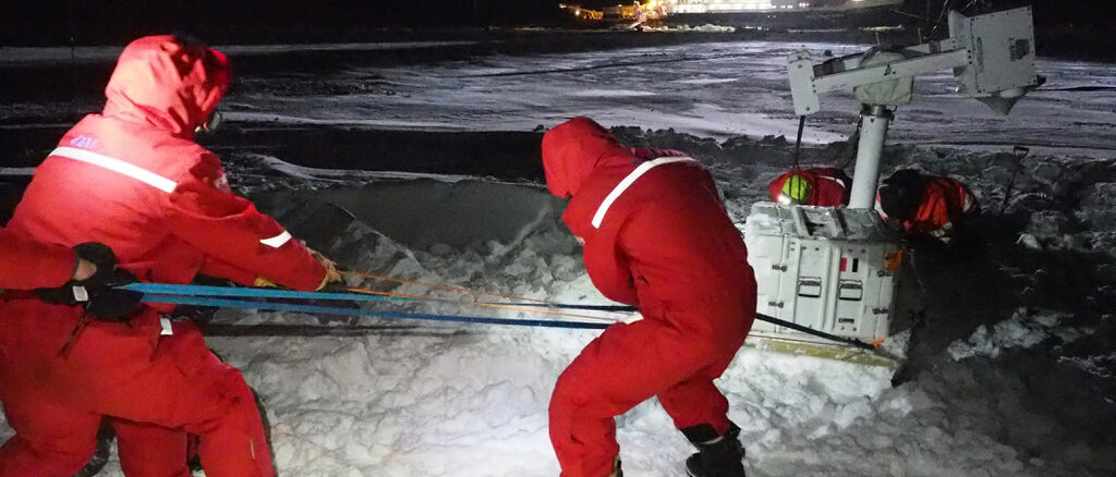 Arctic rearchers installing equipment in harsh conditions