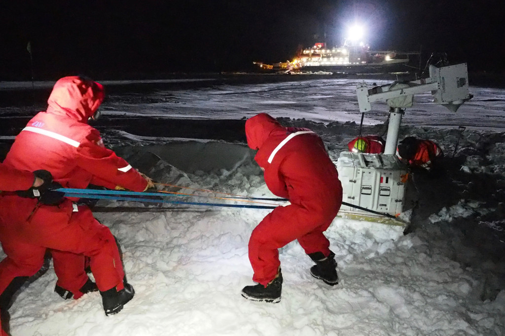 Arctic rearchers installing equipment in harsh conditions